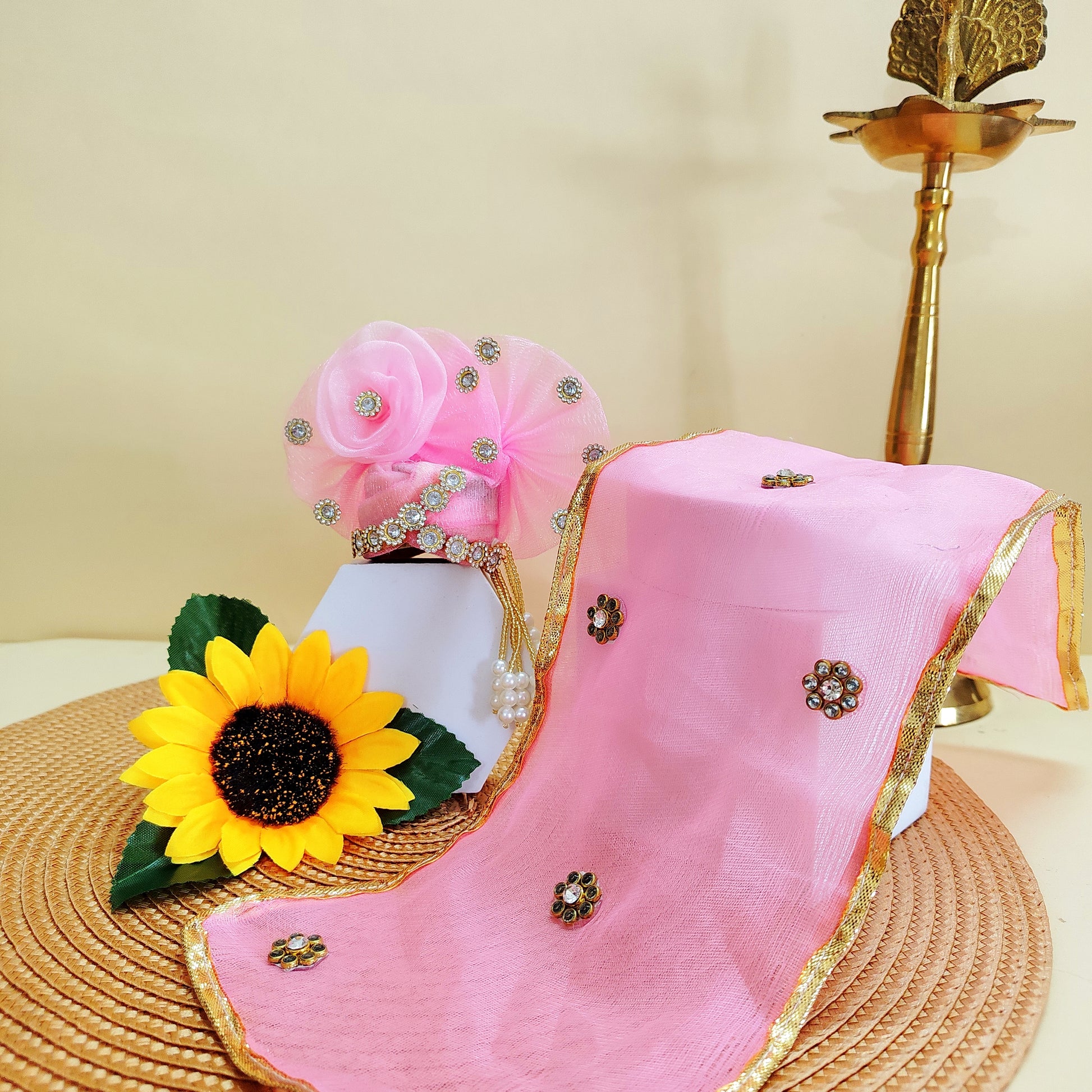 Pink mukut with gold border and decorative elements on a beige background