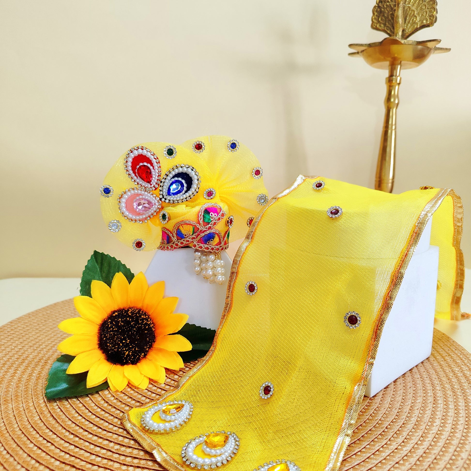 Yellow Mukut Thakur ji with decorative elements on a textured surface