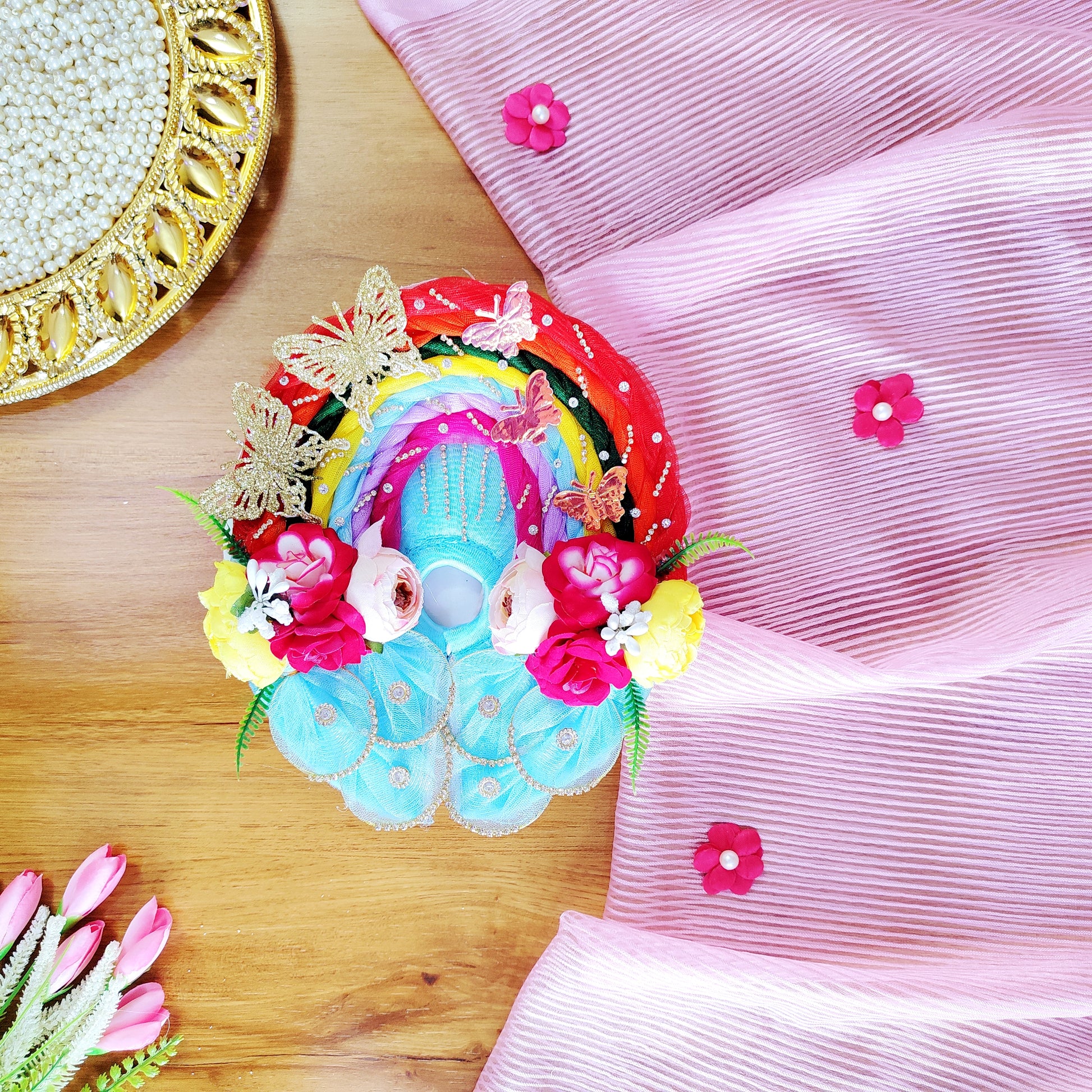 Colorful Kanha ji Dress with flowers and butterflies on a pink fabric background